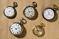 Set of five antique gold and silver pocket watches on beige background. Retro mechanical watch with white dials, hands Royalty Free Stock Photo