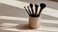 Set of Five Makeup Brushes in a Mug with Dramatic Window Shadow Lighting Royalty Free Stock Photo