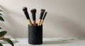 Makeup Brush Set in Black Speckled Container on White Surface with Green Plant Royalty Free Stock Photo