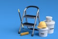 Set of folding ladder, bucket, helmet with paint rollers and brushes on blue. Royalty Free Stock Photo