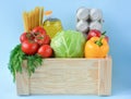 Set of food in a wooden box on a blue background,copy space. Coronavirus Relief Funds and Donations.ÃÂ¡oncept of safety mail goods