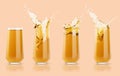 Set of four apple yellow cold juices in glass with reflection, calm and bright splashes, drops flying, swirl pastel beige