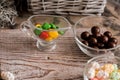 set four bowls of colorful bright round sweet candies yellow blue blue white on a vertical board background Royalty Free Stock Photo