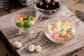 set four bowls of colorful bright round sweet candies yellow blue blue white on a vertical board background Royalty Free Stock Photo