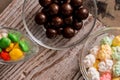 set four bowls of colorful bright round sweet candies yellow blue blue white on a vertical board background Royalty Free Stock Photo