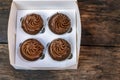 Set of four chocolate mafins in cardboard box. Cupcakes are decorated with chocolate butter cream. Top view Royalty Free Stock Photo