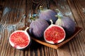 A set of four figs one has been sliced isolated on wooden background Royalty Free Stock Photo