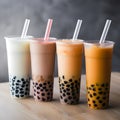 Set of four tall drinking glasses with straws with Taiwanese bubble or boba tea from vegan milk and agava sypur with different