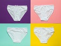 Set of four white women`s panties on a multi-colored background. Flat lay. Royalty Free Stock Photo