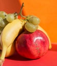 Set of fresh fruits: golden apple, banana, pomegranate and grapes
