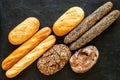 Set of fresh homemade bread. Bread assortment. Loaf, baguette. White and brown bread on black background top view Royalty Free Stock Photo