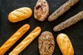 Set of fresh homemade bread. Bread assortment. Loaf, baguette. White and brown bread on black background top view Royalty Free Stock Photo