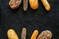 Set of fresh homemade bread. Bread assortment. Loaf, baguette. White and brown bread on black background top view copy Royalty Free Stock Photo