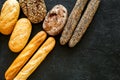 Set of fresh homemade bread. Bread assortment. Loaf, baguette. White and brown bread on black background top view copy Royalty Free Stock Photo