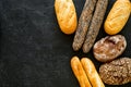 Set of fresh homemade bread. Bread assortment. Loaf, baguette. White and brown bread on black background top view copy Royalty Free Stock Photo