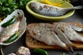 A set of fresh, raw fish in various dishes and with vegetables on a black table Royalty Free Stock Photo