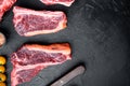 Set of Fresh raw marbled beef steaks, tomahawk, t bone, club steak, rib eye and tenderloin cuts, on black stone background, top Royalty Free Stock Photo