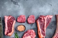 Set of Fresh raw marbled beef steaks, tomahawk, t bone, club steak, rib eye and tenderloin cuts, on gray stone background, top Royalty Free Stock Photo