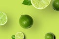 Set of Fresh Ripe Whole and Cut Limes With Leaves and Slices on Bright Green Background. Top View Royalty Free Stock Photo