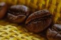 Set of fresh roasted macro coffee beans, yellow wicker basket background. Royalty Free Stock Photo