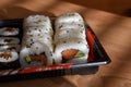 A set of fresh sushi rolls with salmon, avocado and black sesame seeds served on a white plate Royalty Free Stock Photo