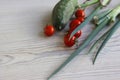 Set of fresh vegetables. Green cucumber, red cherry tomatoes, green Chives. Set with raw food on white wooden background. Healthy Royalty Free Stock Photo