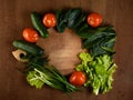 a set of fresh vegetables for salad is spread out around a cutting board. cucumber, lettuce, spinach, tomato and green onion. top Royalty Free Stock Photo