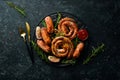 Set of fried barbecue sausages with rosemary and sauces.