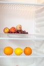 Set of fruits and citrus fruits in empty fridge