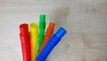 A set of funny plastic multicolored tubes-antistress on a wooden background