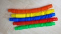 A set of funny plastic multicolored tubes-antistress on a wooden background