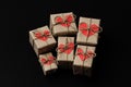 Set of gift boxes on black background. Heart cardboard. Parcels wrapped in craft paper and tie hemp cord.