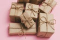 Set of gift boxes. Presents wrapped in brown craft paper and tie hemp string. Light pink background. Royalty Free Stock Photo