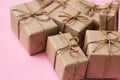 Set of gift boxes. Presents wrapped in brown craft paper and tie hemp string. Light pink background. Royalty Free Stock Photo