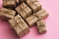 Set of gift boxes. Presents wrapped in brown craft paper and tie hemp string. Light pink background. Royalty Free Stock Photo