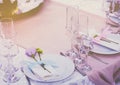 A set of glass of wedding setting with cutlery with a violet flower rose . Table for an event party or wedding reception. Royalty Free Stock Photo