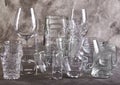 Set of glasses of different sizes and for different drinks on gray biton background