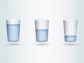 A set of glasses with different water levels on light blue background Royalty Free Stock Photo