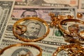 A set of gold accessories of rings, chains and bracelets on American dollars banknotes money of different values Royalty Free Stock Photo