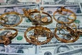 A set of gold accessories of rings, chains and bracelets on American dollars banknotes money of different values