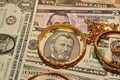 A set of gold accessories of rings, chains and bracelets on American dollars banknotes money of different values Royalty Free Stock Photo