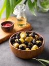 A set of green and black dried olives in bowl on a dark background with olive oil and eucalyptus branch close up. The concept of Royalty Free Stock Photo
