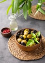 A set of green and black dried olives in bowl on a dark background with olive oil and eucalyptus branch. The concept of vegetarian Royalty Free Stock Photo