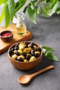 A set of green and black dried olives in bowl on a dark background with olive oil and eucalyptus branch. The concept of vegetarian Royalty Free Stock Photo