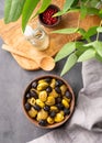 A set of green and black dried olives in bowl on a dark background with olive oil and eucalyptus branch. The concept of vegetarian Royalty Free Stock Photo