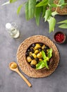 A set of green and black dried olives in bowl on a dark background with olive oil and eucalyptus branch. The concept of vegetarian Royalty Free Stock Photo