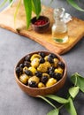 A set of green and black dried olives in bowl on a dark background with olive oil and eucalyptus branch. The concept of vegetarian Royalty Free Stock Photo