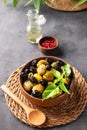 A set of green and black dried olives in bowl on a dark background with olive oil and red pepper close up. The concept of Royalty Free Stock Photo