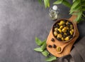 A set of green and black dried olives in bowl on a wooden cutting board on a dark background with olive oil and eucalyptus branch Royalty Free Stock Photo