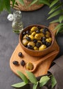 A set of green and black dried olives in bowl on a wooden cutting board on a dark background with olive oil and eucalyptus branch Royalty Free Stock Photo